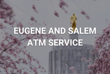 The words "Eugene and Salem ATM Service" are across the image in white. It is an overcast morning in early spring, the cherry blossoms are falling on screen. Two fuzzy cherry blossom trees are in the foreground. In the background stands a shining gold statute atop a linen grey government building.