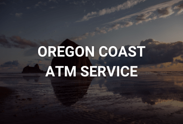 The words "Oregon Coast ATM Service" are across the image in white. The image is of the iconic canon beach rock that towers above near the ocean shoreline.